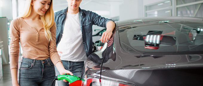 Couple shopping for an electric vehicle. She's charging it.