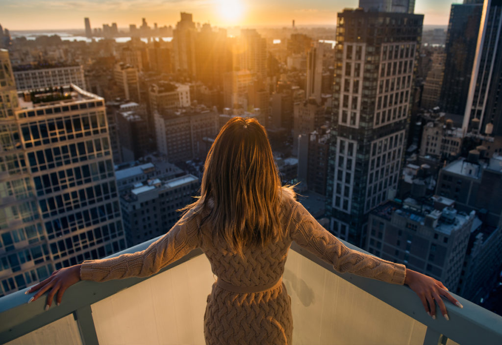 rich woman on balcony watching the sunset