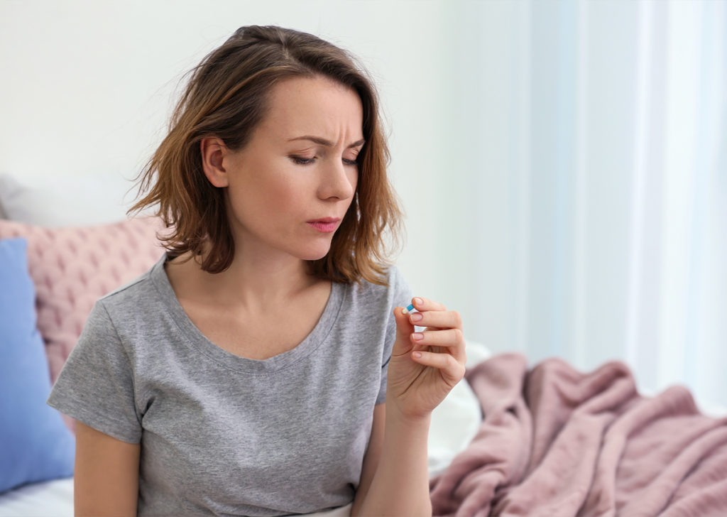 woman holding an antidepressant pill.