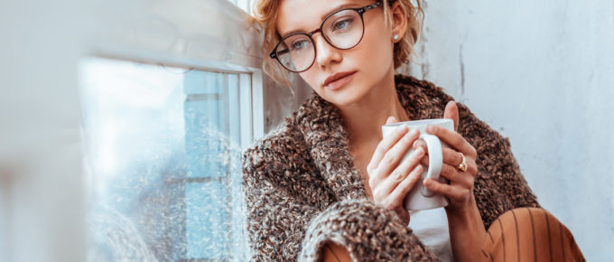 Girl feeling sad and alone leaning against window