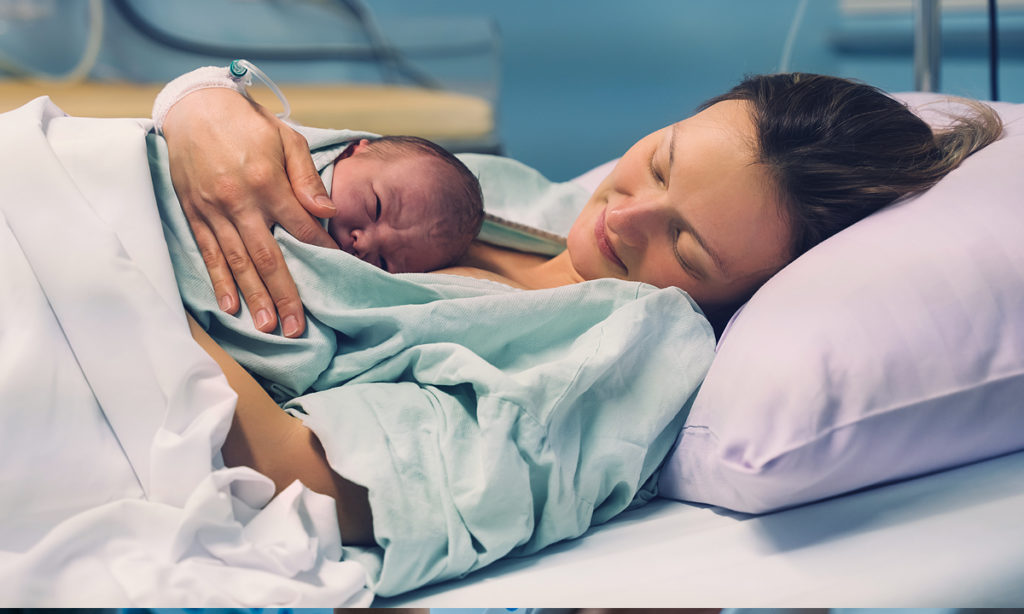 woman holding baby after birth.